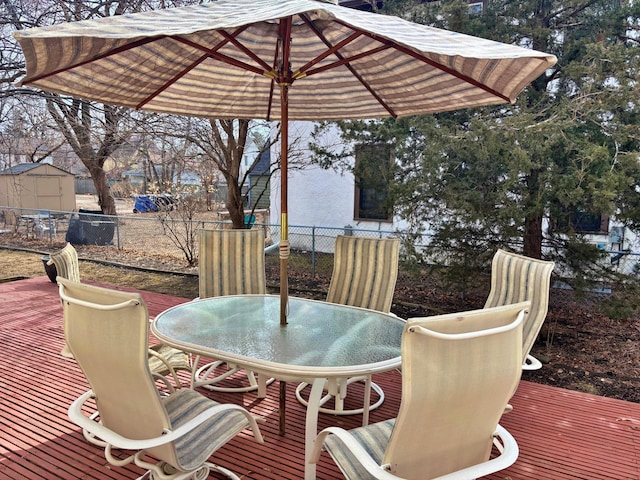 wooden terrace featuring outdoor dining area and fence