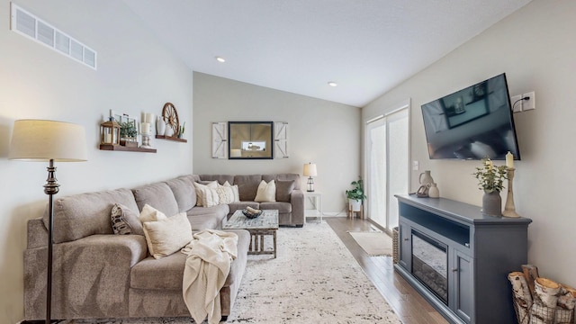 living area featuring dark wood finished floors, lofted ceiling, recessed lighting, and visible vents