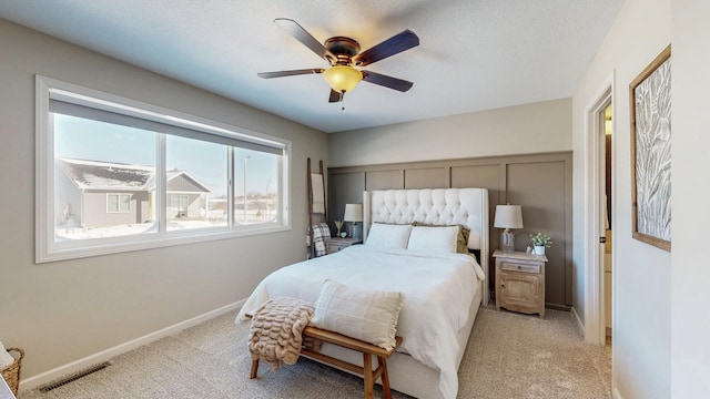 bedroom featuring visible vents, baseboards, light colored carpet, and a textured ceiling