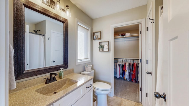 full bathroom featuring a spacious closet, toilet, and vanity