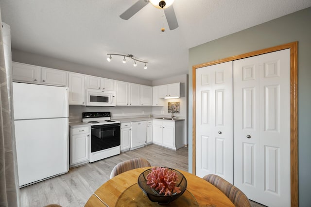 kitchen with light wood finished floors, ceiling fan, light countertops, white cabinets, and white appliances