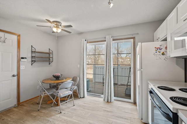 dining space featuring baseboards, light wood-style flooring, a textured ceiling, and ceiling fan