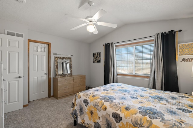 bedroom featuring a ceiling fan, visible vents, vaulted ceiling, a textured ceiling, and carpet flooring