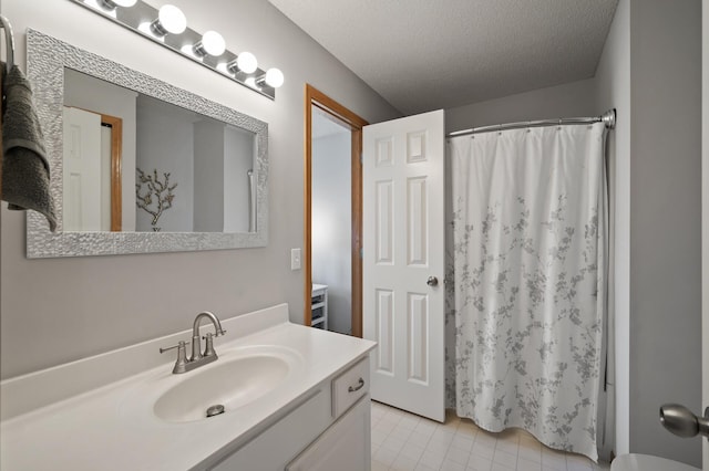 bathroom with curtained shower, a textured ceiling, vanity, and tile patterned flooring