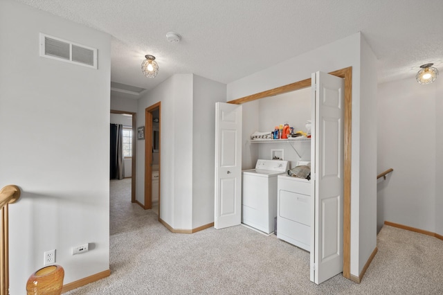 washroom featuring washer and dryer, laundry area, visible vents, and light carpet