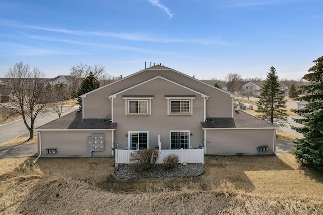 rear view of house with roof with shingles