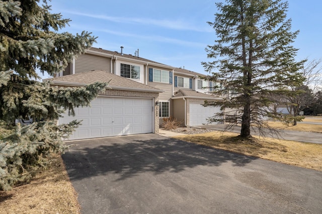 view of front of property with a garage, driveway, and a shingled roof