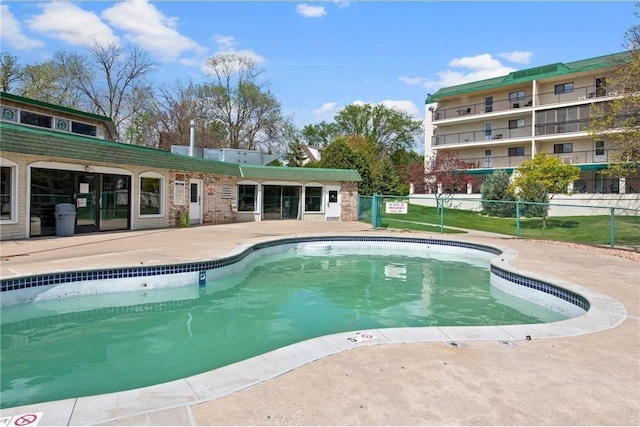 pool with a patio area and fence