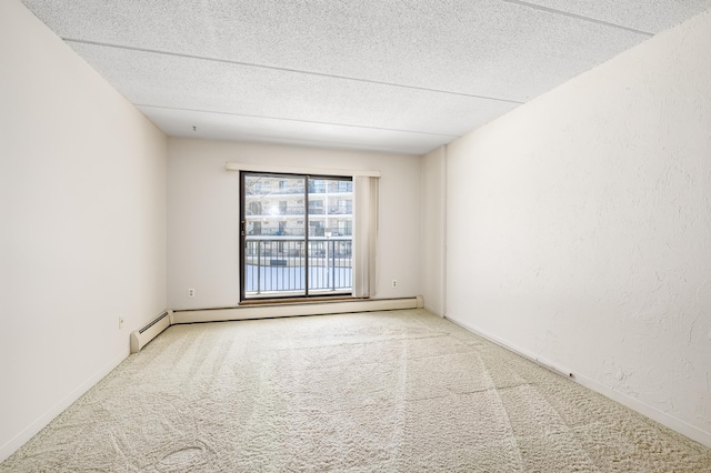 spare room with a baseboard heating unit, carpet floors, a textured ceiling, and a textured wall