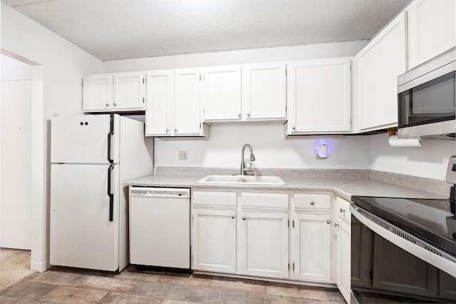 kitchen with a sink, stainless steel appliances, light countertops, a textured ceiling, and white cabinetry