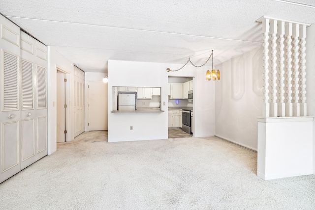 unfurnished living room featuring light colored carpet and a textured ceiling