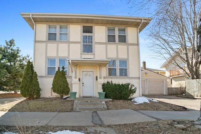 view of front of home featuring stucco siding, an outbuilding, a garage, and concrete driveway