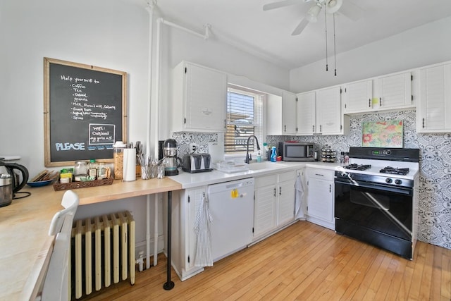 kitchen with stainless steel microwave, gas stove, radiator, light countertops, and dishwasher