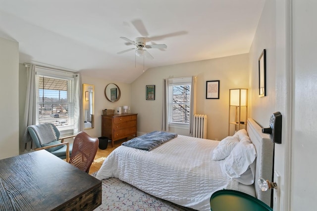 bedroom with radiator, a ceiling fan, lofted ceiling, and wood finished floors