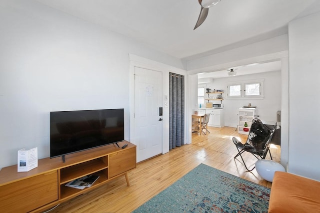 living room with ceiling fan and wood finished floors