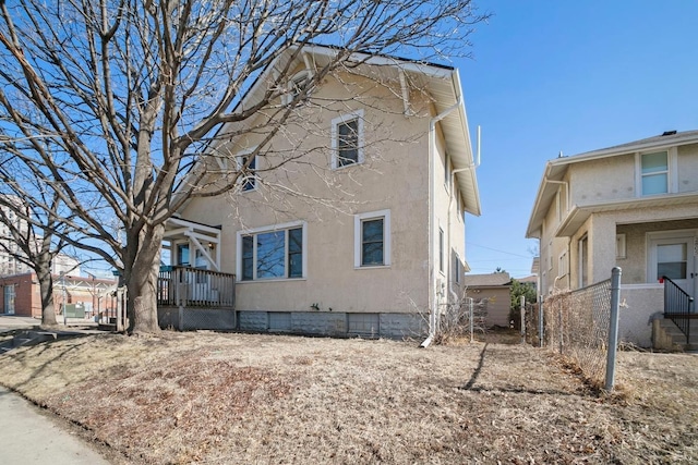 view of property exterior with stucco siding and fence