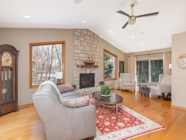 living room with ceiling fan, a fireplace, lofted ceiling, and wood finished floors