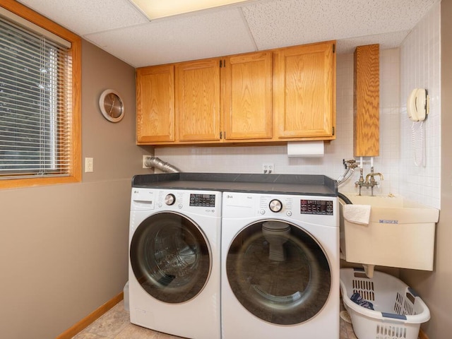 laundry room featuring a sink, baseboards, cabinet space, and washer and clothes dryer