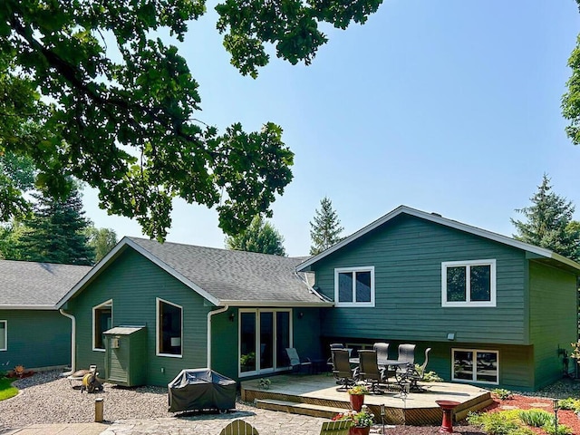 rear view of house with a shingled roof