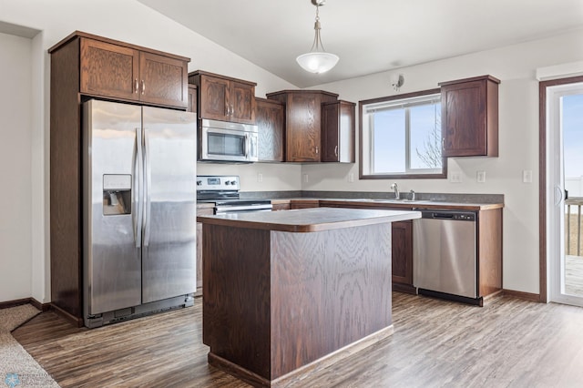 kitchen with stainless steel appliances, dark brown cabinetry, dark wood-style floors, and vaulted ceiling