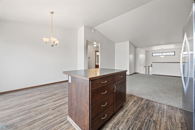 kitchen featuring dark wood-style floors, freestanding refrigerator, an inviting chandelier, baseboards, and vaulted ceiling