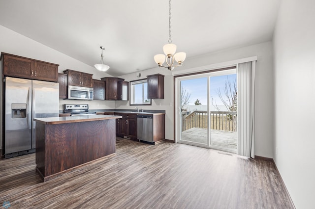 kitchen featuring dark wood finished floors, lofted ceiling, dark brown cabinets, appliances with stainless steel finishes, and a center island