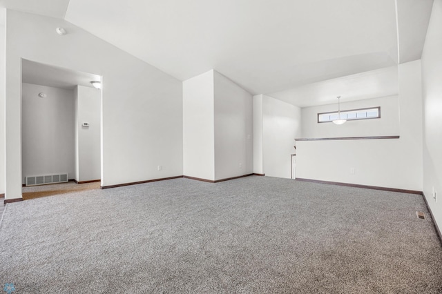 carpeted empty room featuring visible vents, lofted ceiling, and baseboards