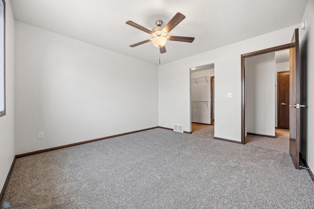 unfurnished bedroom featuring visible vents, carpet floors, baseboards, a spacious closet, and a closet