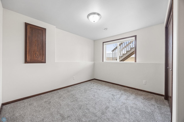 spare room featuring baseboards and carpet