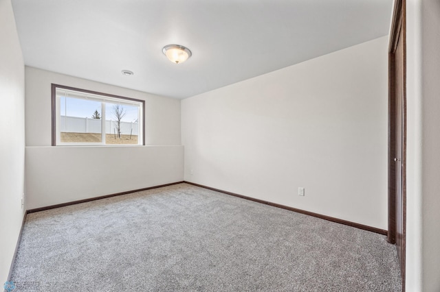 spare room with carpet and baseboards