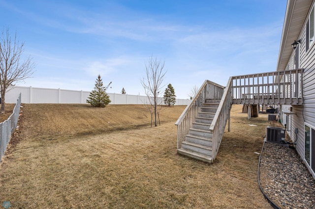 view of yard with stairs, a fenced backyard, central AC, and a wooden deck