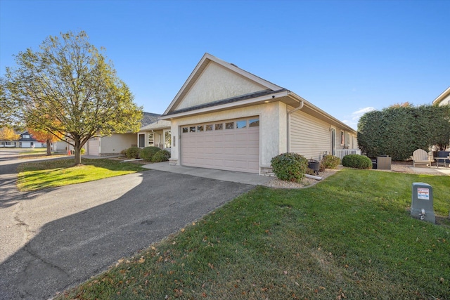 view of front facade with stucco siding, driveway, an attached garage, and a front yard