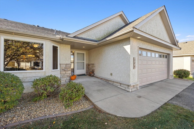 view of exterior entry with stucco siding, stone siding, and an attached garage