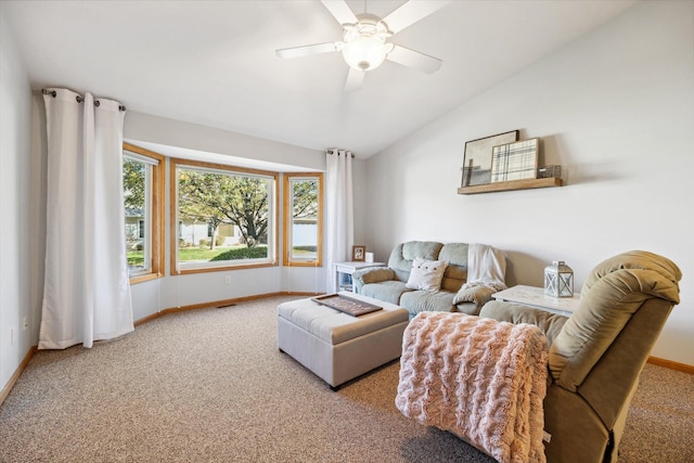 carpeted living room featuring baseboards, a ceiling fan, and vaulted ceiling