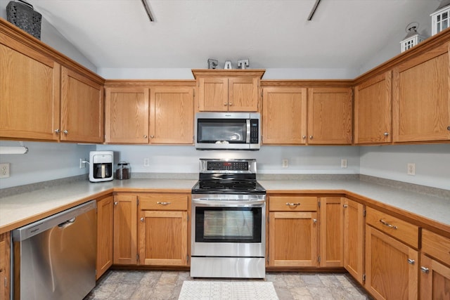 kitchen featuring light countertops, stone finish floor, and appliances with stainless steel finishes