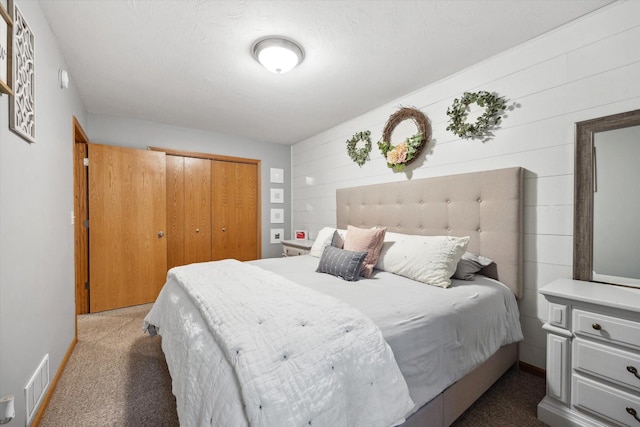 carpeted bedroom with visible vents and a closet