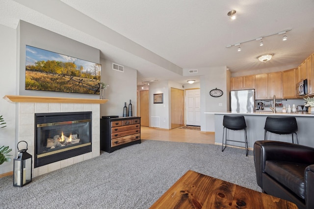 545 1st St Unit 410, Minneapolis, MN 55401 - living room featuring light colored carpet, visible vents, and a tile fireplace
