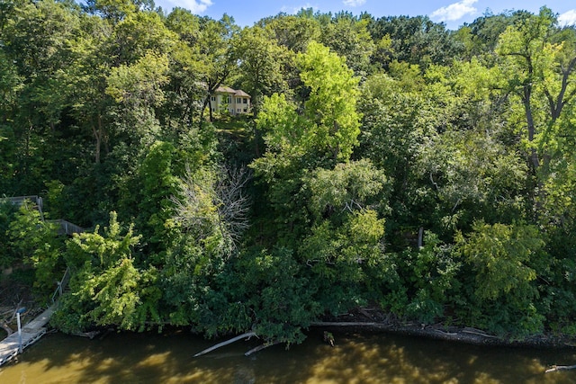 exterior space featuring a wooded view and a water view