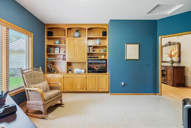 living area with light colored carpet and baseboards