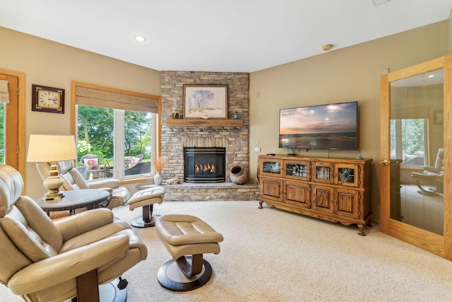 carpeted living room featuring recessed lighting and a stone fireplace