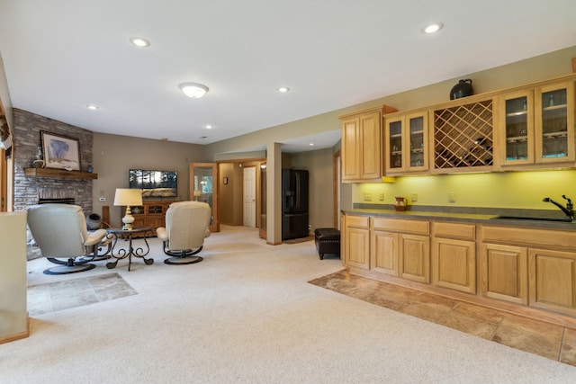 interior space with wet bar, recessed lighting, light colored carpet, and a large fireplace