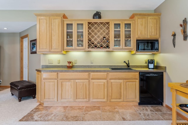 kitchen featuring black appliances, glass insert cabinets, light brown cabinetry, and a sink