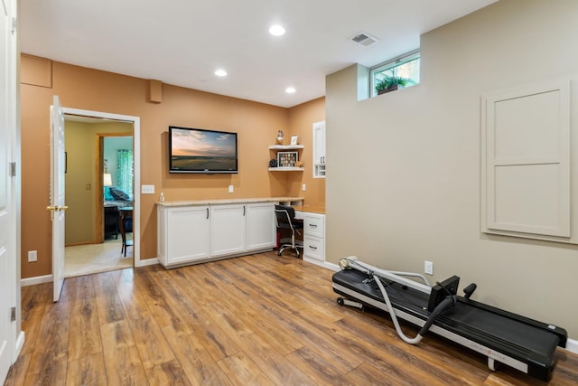 workout area featuring visible vents, light wood-style flooring, recessed lighting, baseboards, and built in study area