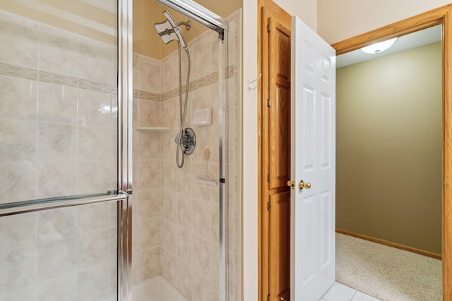 bathroom featuring a shower stall and baseboards