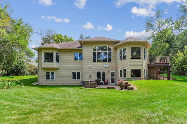 back of property with a yard, a patio, and a wooden deck