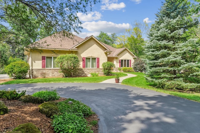 single story home with stucco siding and a front lawn