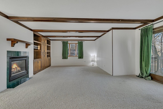 unfurnished living room with beam ceiling, carpet flooring, and a healthy amount of sunlight