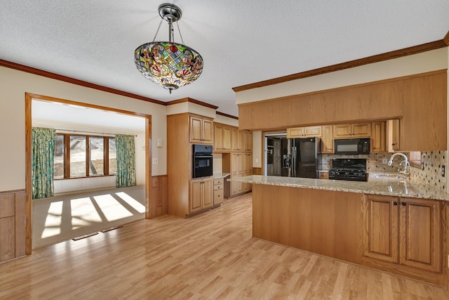 kitchen with ornamental molding, a textured ceiling, black appliances, and a sink