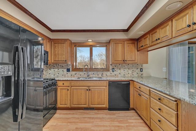 kitchen featuring visible vents, crown molding, light stone countertops, black appliances, and a sink