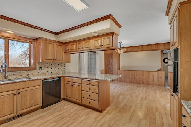 kitchen with visible vents, a sink, light stone counters, black dishwasher, and a peninsula